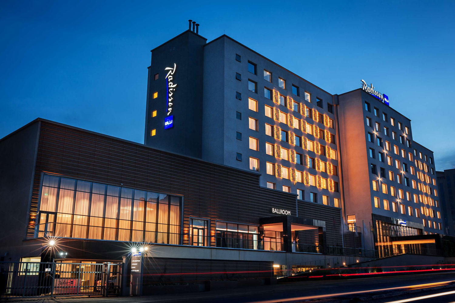 Exterior view of a Radisson Blu hotel building illuminated at night